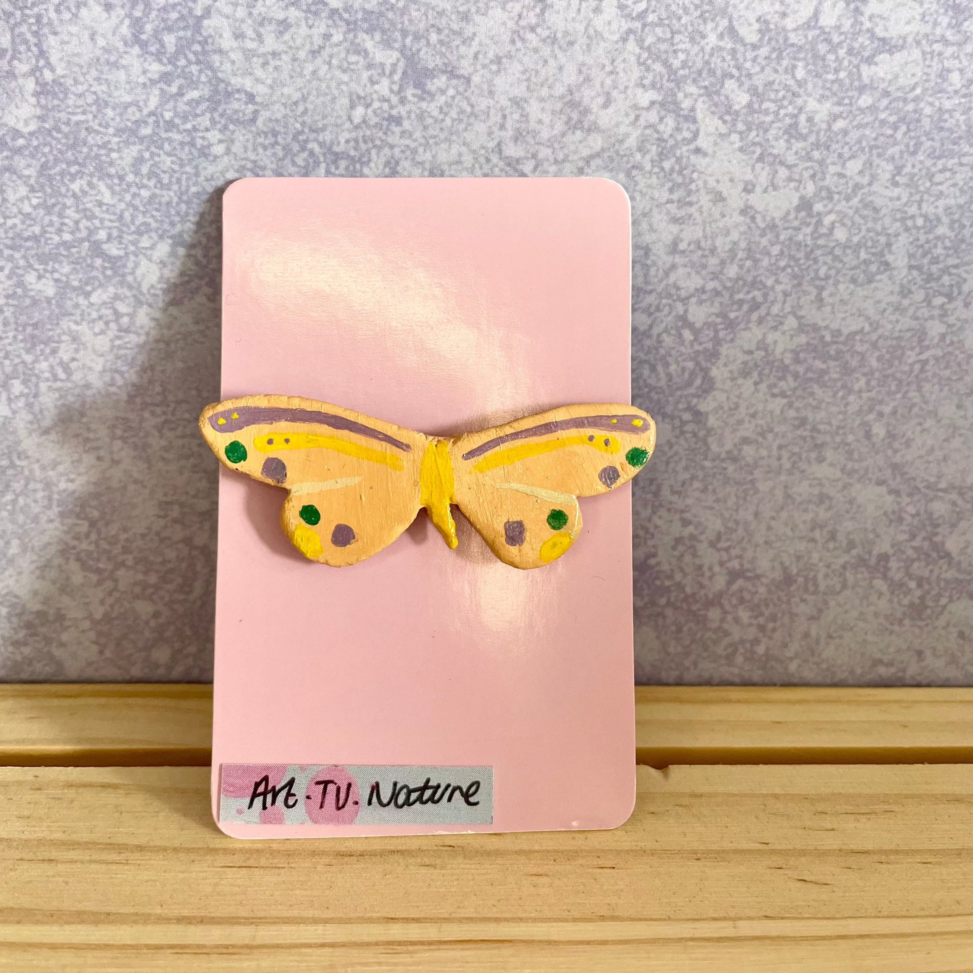 clay butterfly pin , on pink backing card 