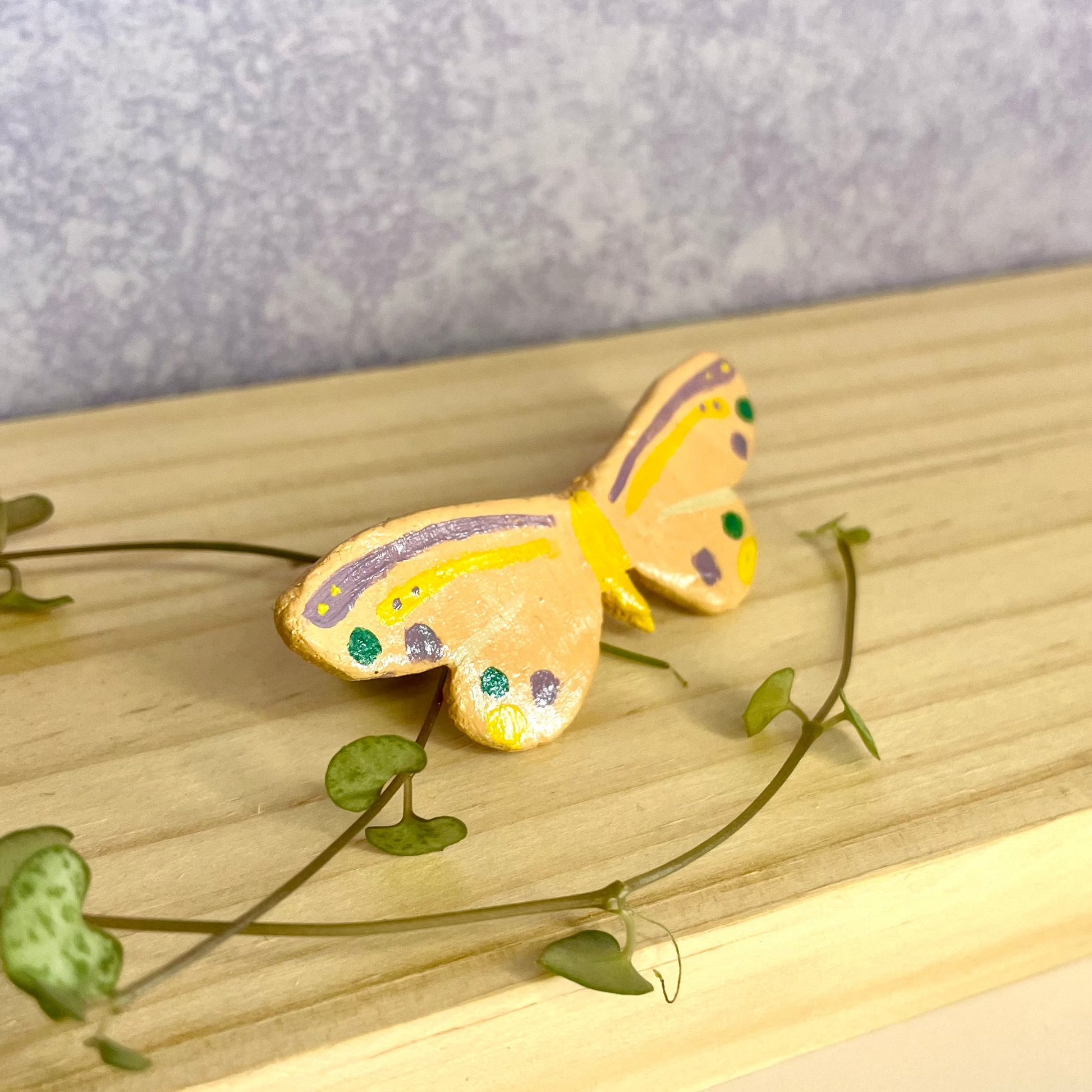 clay butterfly pin , on pink backing card 