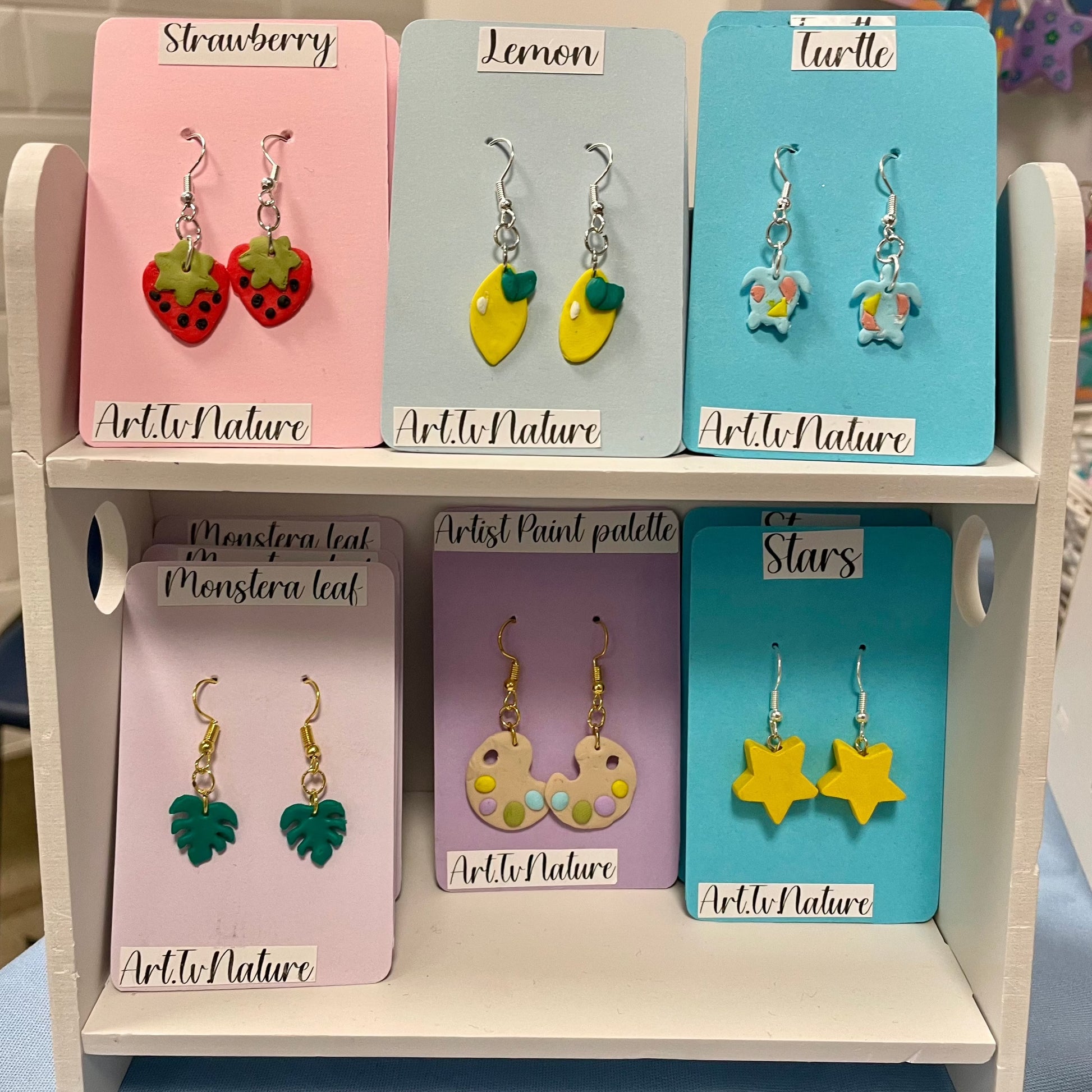 lemon polymer clay earrings on a display with other earring designs