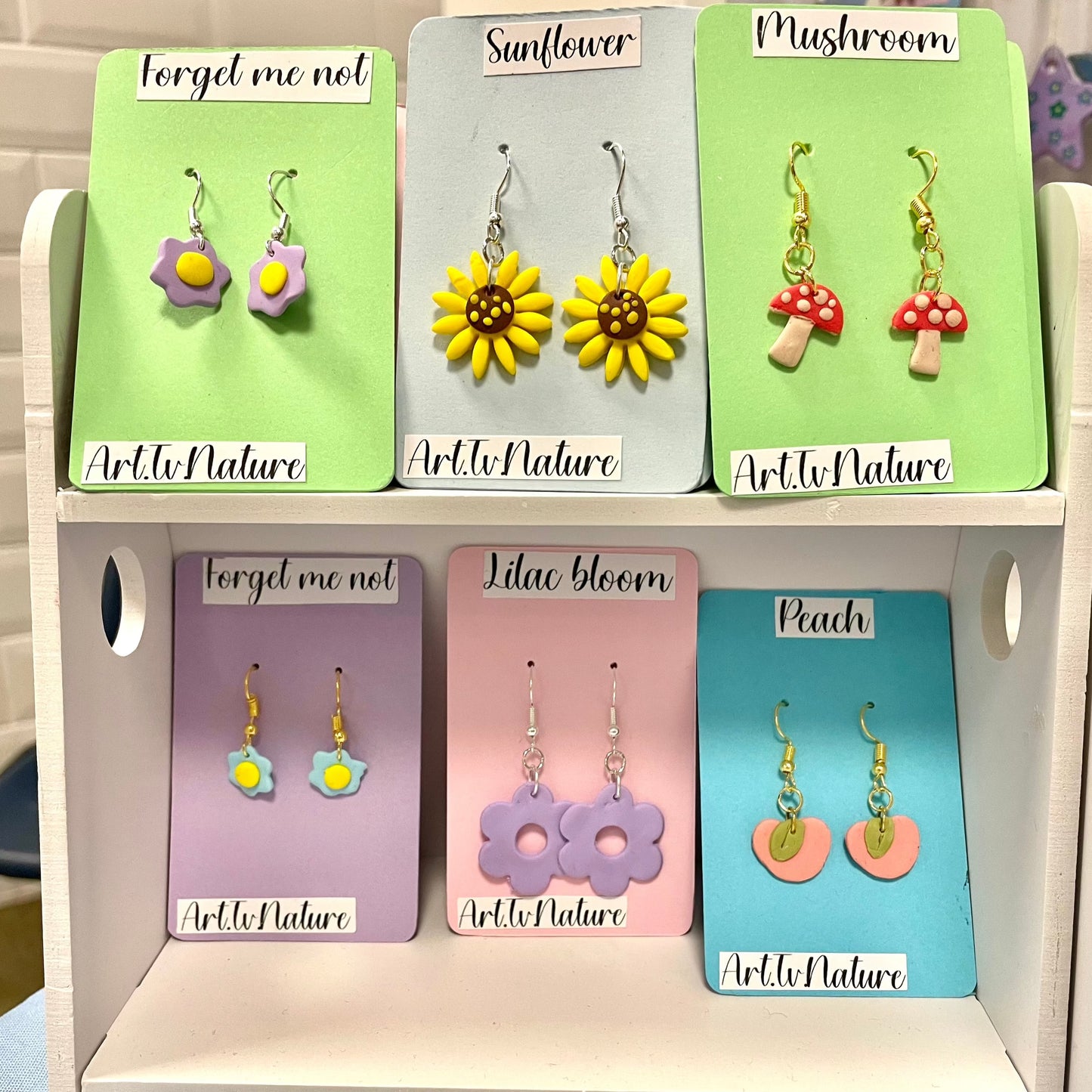 Peach polymer clay earrings on a display with other designs